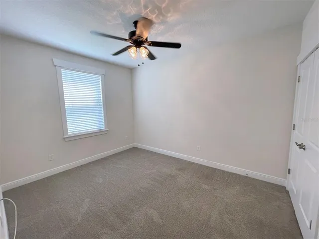 an empty room with a window and a fan