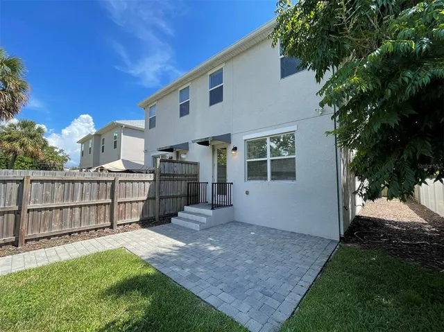 a view of a house with a yard and wooden fence