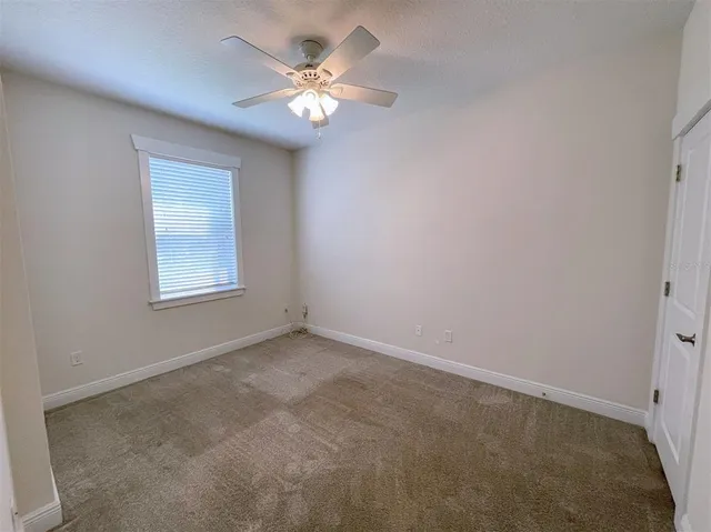 an empty room with a chandelier fan