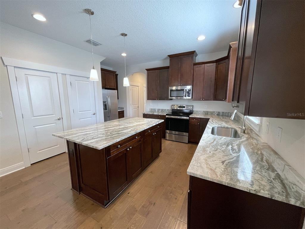 2411 West North A Street, Unit 2 Tampa, FL 33609 - Photo 6 of 19 a kitchen with granite countertop kitchen island stainless steel appliances a sink stove top oven and cabinets