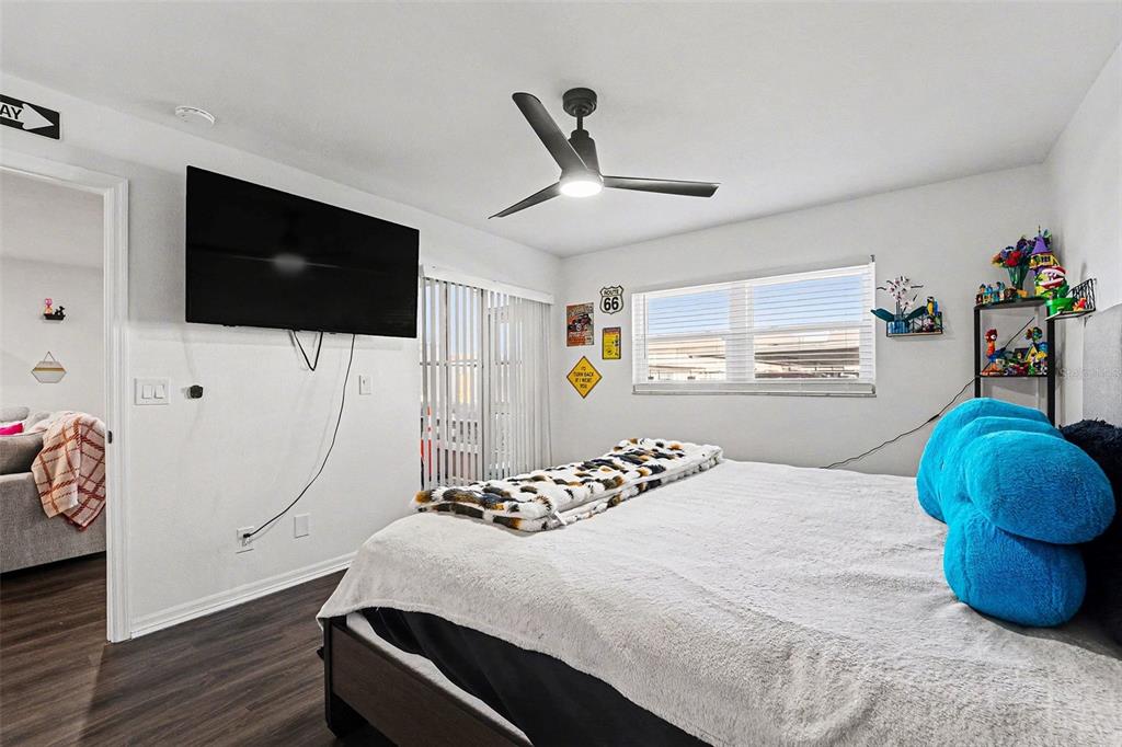 5197 Silent Loop, Unit 121 New Port Richey, FL 34652 - Photo 13 of 36 a bedroom with a bed and flat tv screen on the dresser