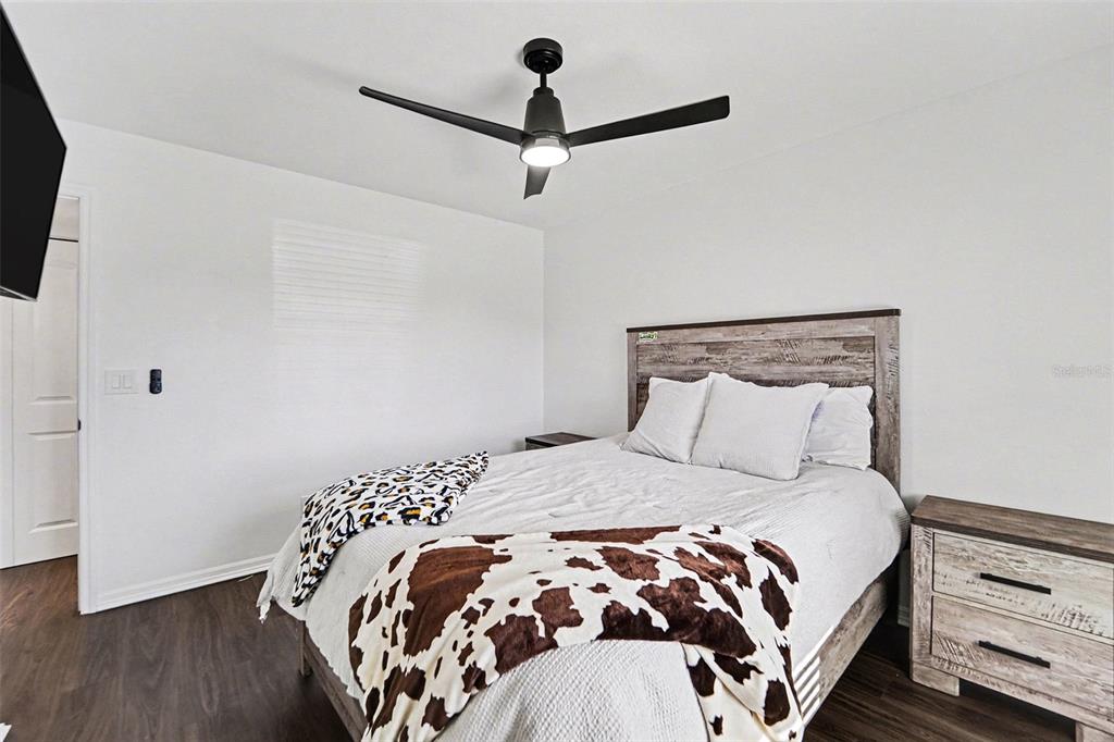 5197 Silent Loop, Unit 121 New Port Richey, FL 34652 - Photo 15 of 36 a bedroom with a bed and a flat tv screen on a dresser