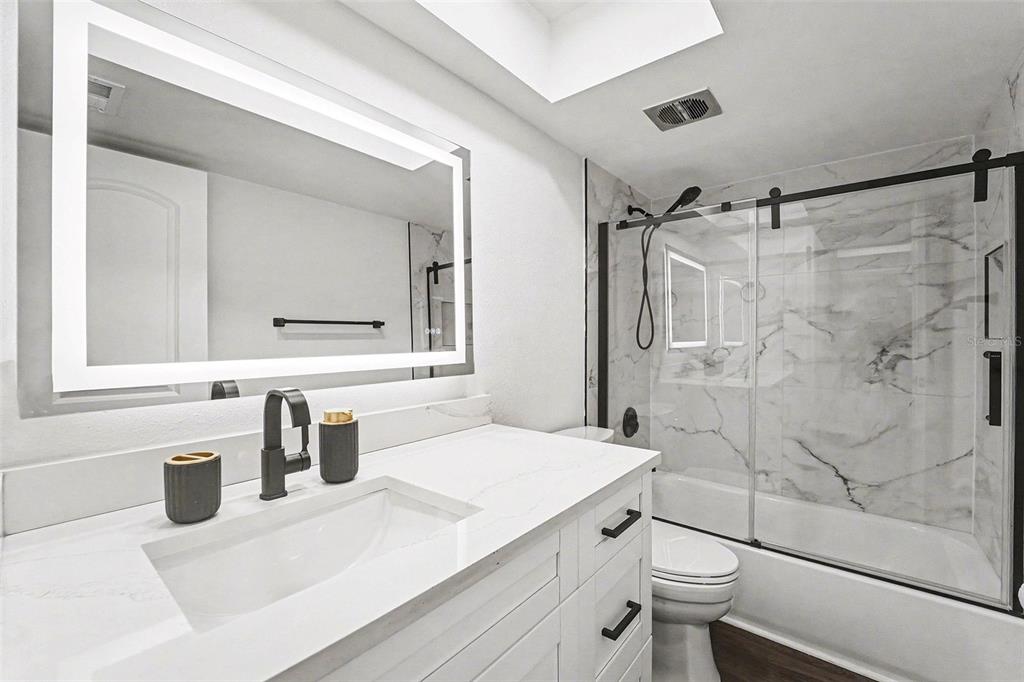 5197 Silent Loop, Unit 121 New Port Richey, FL 34652 - Photo 18 of 36 a bathroom with a sink a toilet and shower