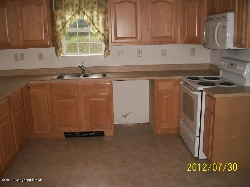 162 Stonecrest Road Blakeslee, PA 18610 - Photo 3 of 15 a kitchen with granite countertop a sink a stove and a refrigerator