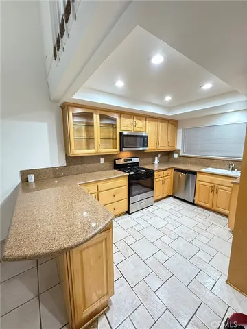 a kitchen with stainless steel appliances granite countertop a sink dishwasher stove top oven and cabinets with wooden floor
