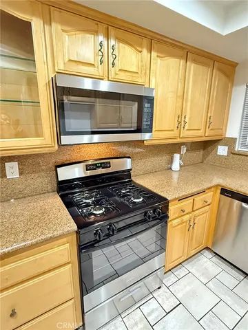 a kitchen with granite countertop cabinets stainless steel appliances and a window