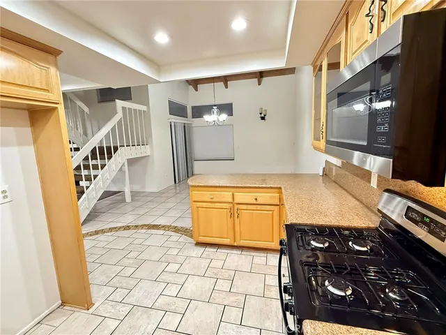 a kitchen with stainless steel appliances granite countertop a stove and a wooden cabinets
