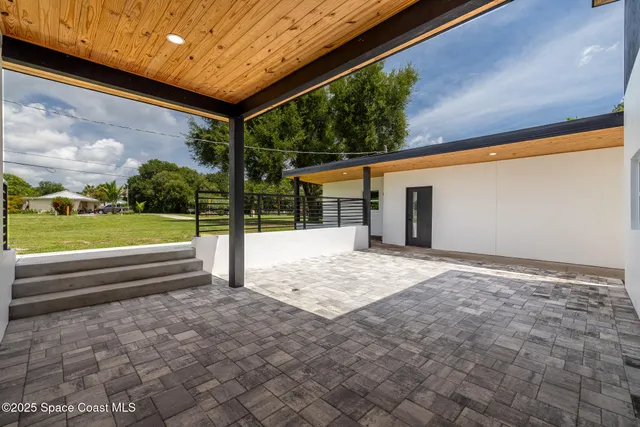 a view of a house with a yard and a large tree