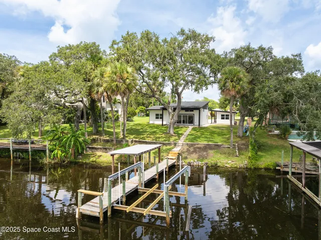 an aerial view of residential houses with outdoor space and lake view