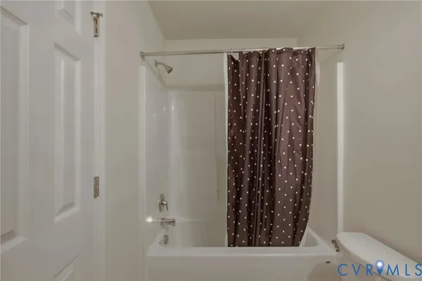 a bathroom with a granite countertop bathtub shower sink vanity mirror and toilet