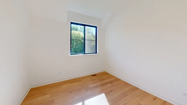 a view of a room with wooden floor and a window