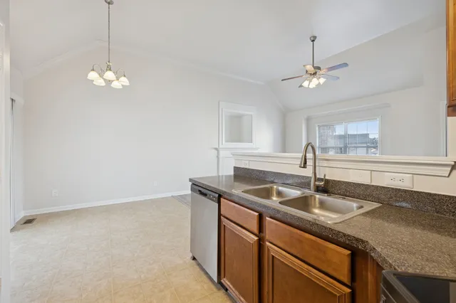 a kitchen with a sink a chandelier and wooden floor