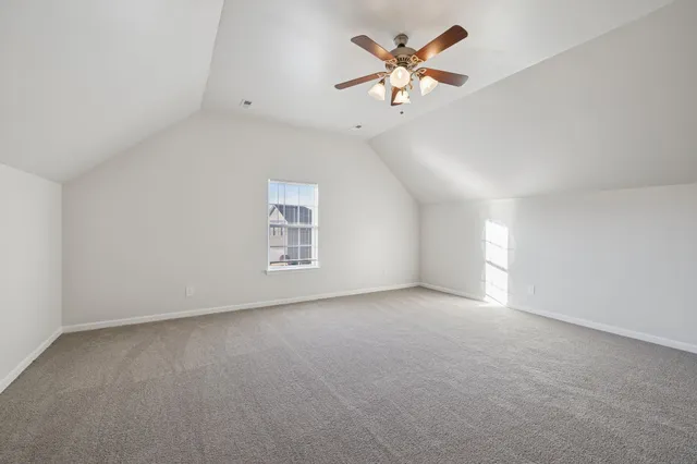 an empty room with a window and a ceiling fan