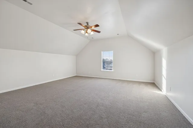an empty room with windows and ceiling fan view