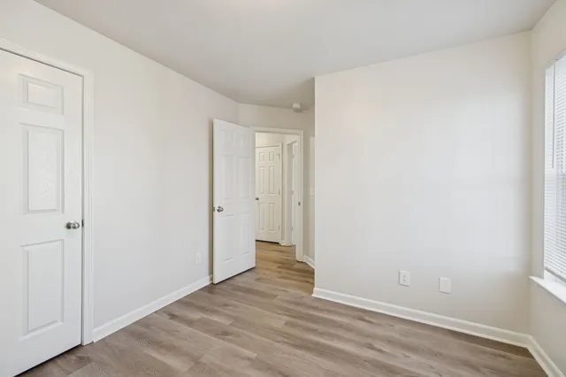 a view of an empty room with wooden floor