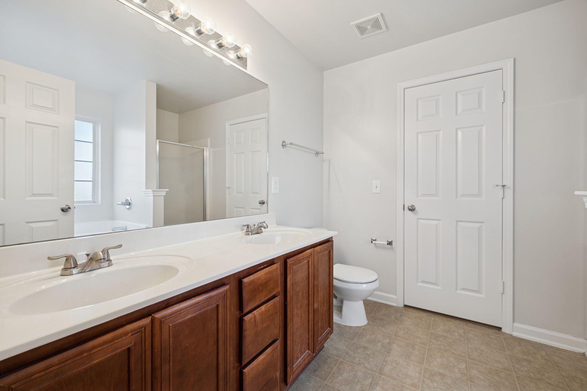8010 Tiger Court Spring Hill, TN 37174 - Photo 27 of 36 a bathroom with a granite countertop sink a toilet and a large mirror