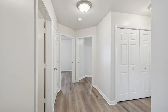 a view of a hallway with wooden floor