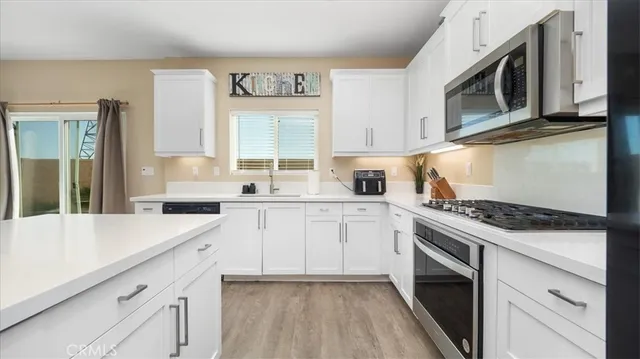 a kitchen with cabinets appliances a sink and a window