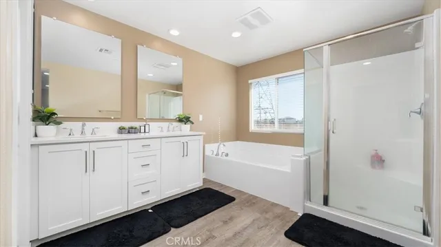 a bathroom with a double vanity sink a mirror a bathtub and shower