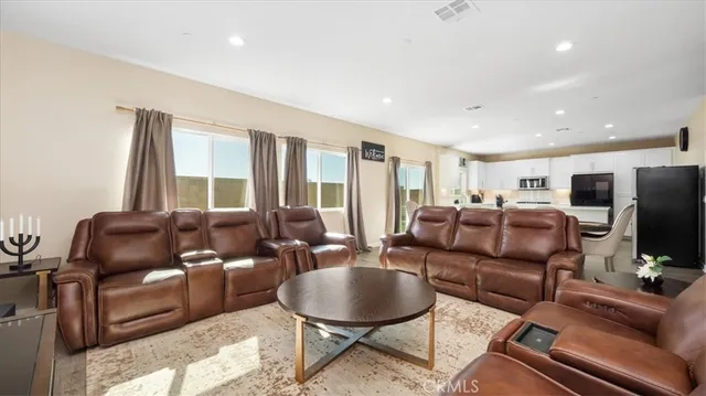 a living room with furniture a flat screen tv and a window