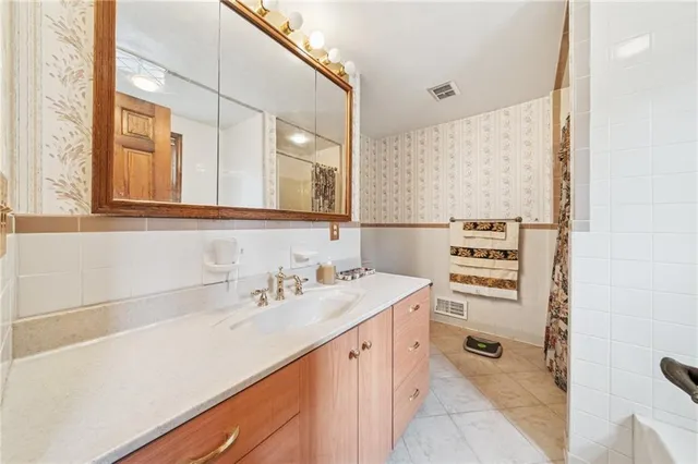a spacious bathroom with a sink a mirror and a bathtub