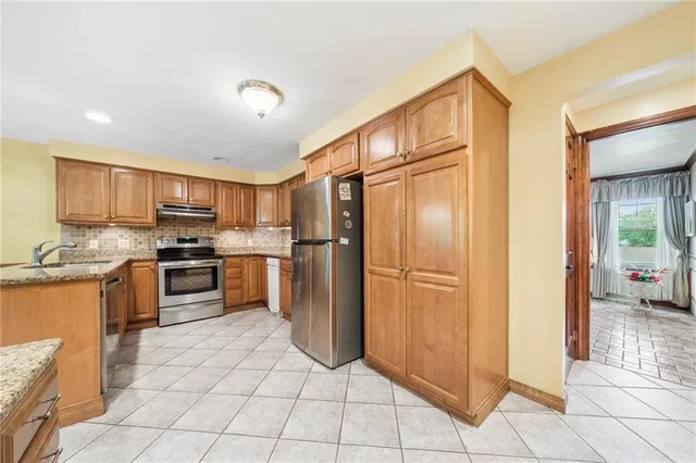 a kitchen with stainless steel appliances granite countertop a refrigerator and a stove top oven