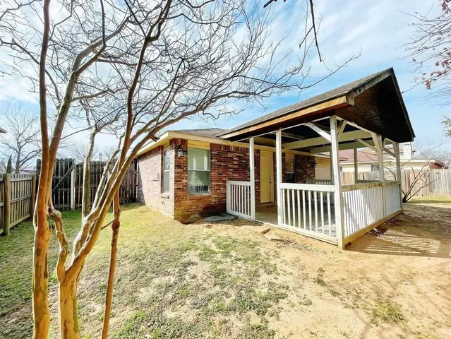 a view of a house with a large window and wooden fence