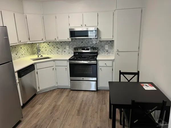 a kitchen with a stove a refrigerator and a table