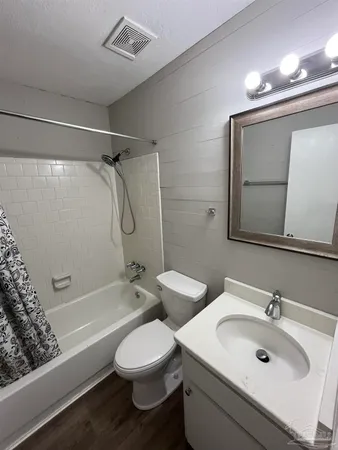 a bathroom with a double vanity sink toilet mirror and shower