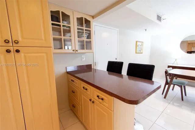 a kitchen with stainless steel appliances kitchen island granite countertop a table and a chair