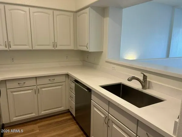 a kitchen with stainless steel appliances white cabinets and a refrigerator