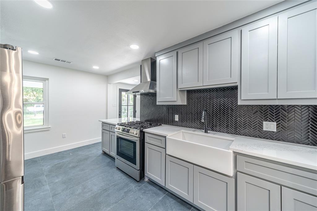 932 Treasure Road Garland, TX 75041 - Photo 8 of 28 Kitchen featuring gray cabinets, backsplash, stainless steel appliances, light stone countertops, and healthy amount of natural light