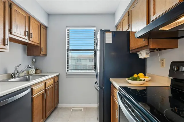 a kitchen with stainless steel appliances granite countertop a sink stove and cabinets