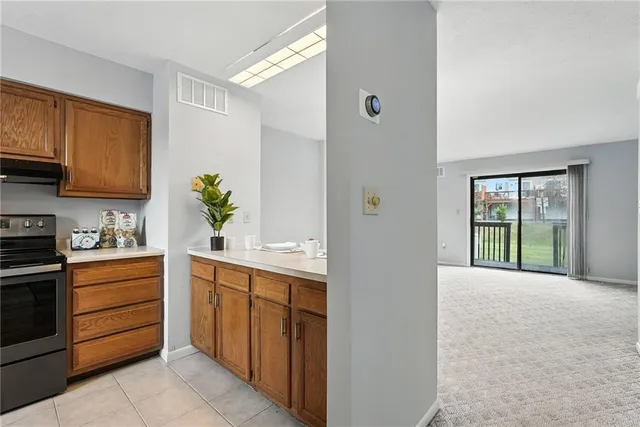 a large white kitchen with a sink and dishwasher a stove top oven with wooden floor