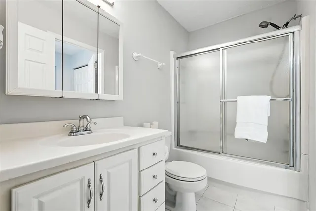 a bathroom with a sink toilet and shower glass cabinet