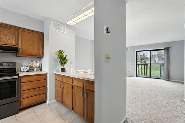 a large white kitchen with a sink and dishwasher a stove top oven with wooden floor