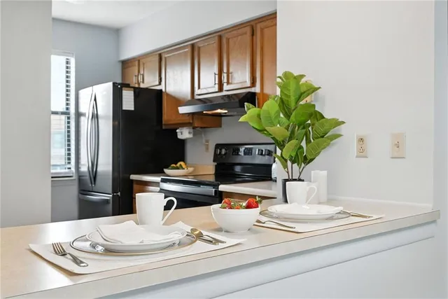 a kitchen with stainless steel appliances kitchen island granite countertop a refrigerator a stove a microwave and cabinets