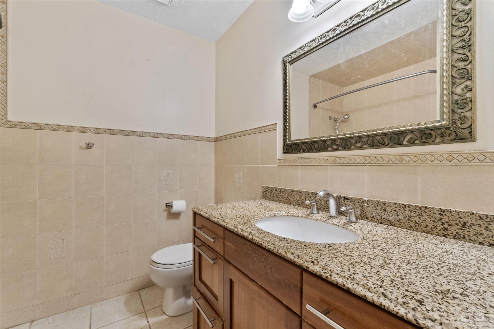 1151 Stone Bridge Road Pensacola, FL 32514 - Photo 33 of 52 a bathroom with a granite countertop sink a mirror and a toilet