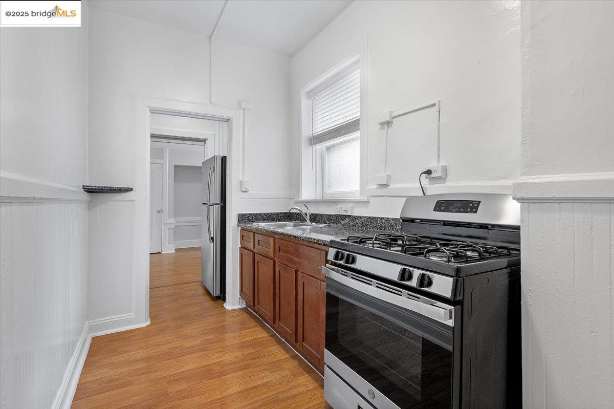 184 13th Street Oakland, CA 94612 - Photo 8 of 17 a kitchen with stainless steel appliances a stove and white cabinets