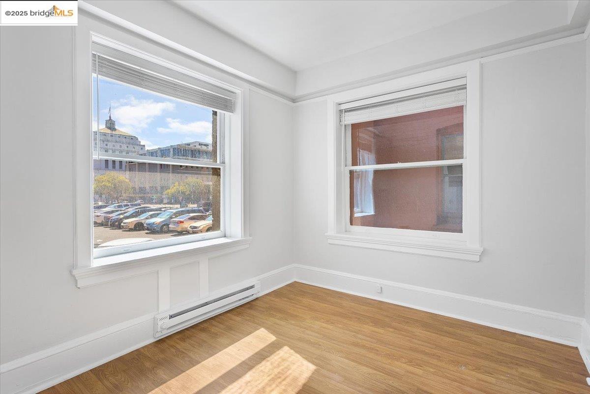 184 13th Street Oakland, CA 94612 - Photo 10 of 17 an empty room with wooden floor and windows