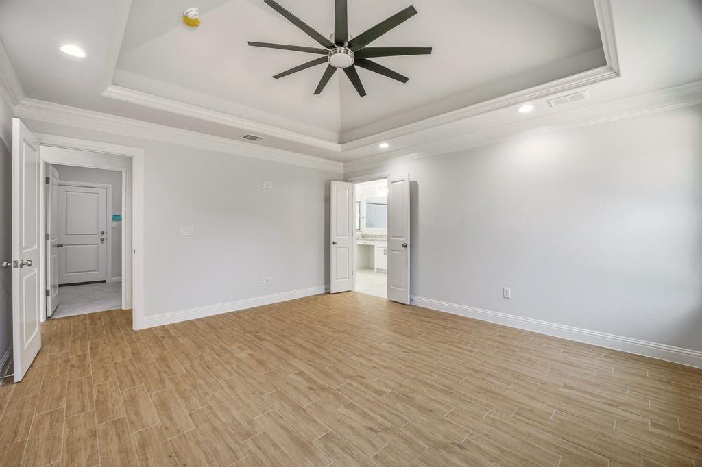 2017 Forest Bridge Azle, TX 76020 - Photo 15 of 30 Unfurnished room with ceiling fan, wood tiled floors, recessed lighting, a tray ceiling, and crown molding