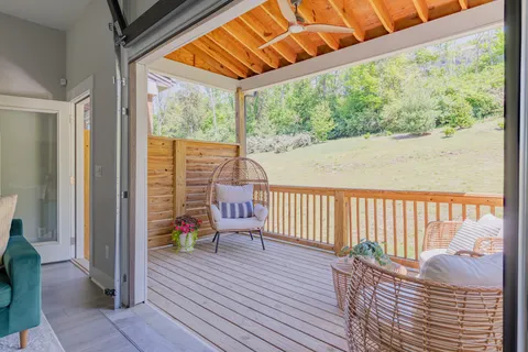 a balcony with wooden floor table and chairs