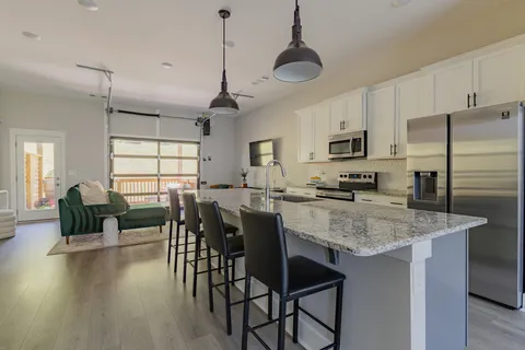 a kitchen with a center island white cabinets and stainless steel appliances
