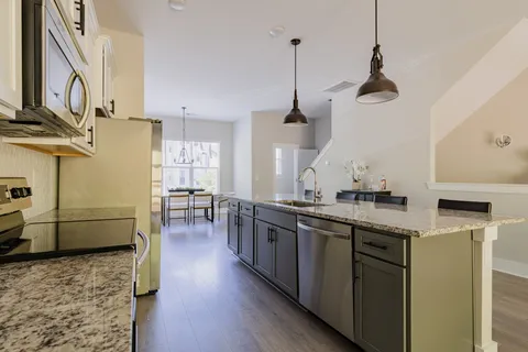 a kitchen with stainless steel appliances granite countertop a sink a stove and refrigerator