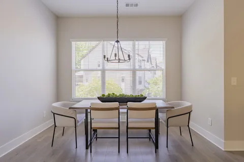 a dining room with furniture a chandelier and wooden floor