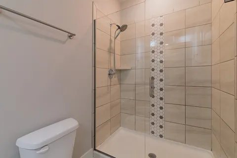 a bathroom with a shower a toilet and sink