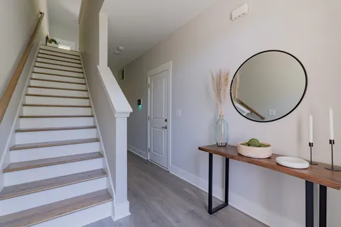 a view of a hallway with wooden floor and entryway