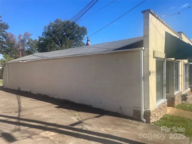 en empty room with chandelier fan and refrigerator