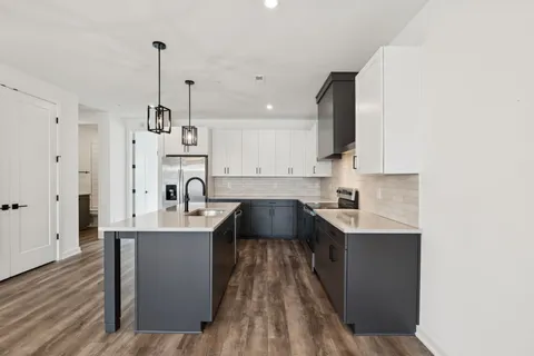 a large kitchen with a lot of cabinets and stainless steel appliances