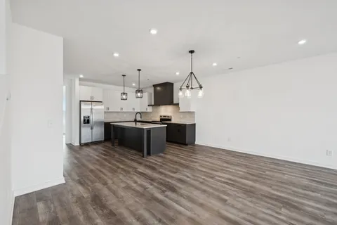 a view of empty room with wooden floor and window